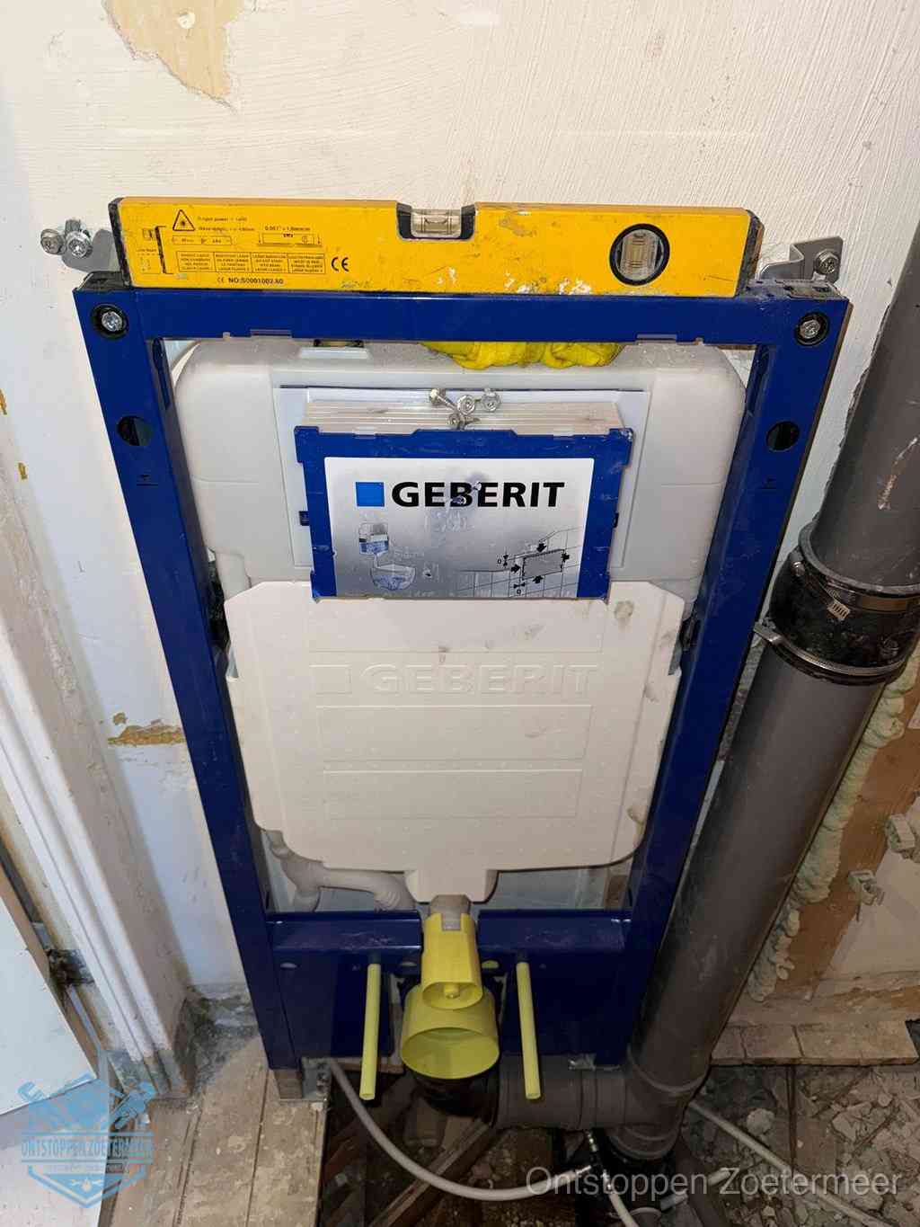 Een Geberit inbouwreservoir met frame voor een hangtoilet tegen de wand, met de afvoerbocht naar de vloer, kenmerkend voor een verstopt hangtoilet in Zoetermeer