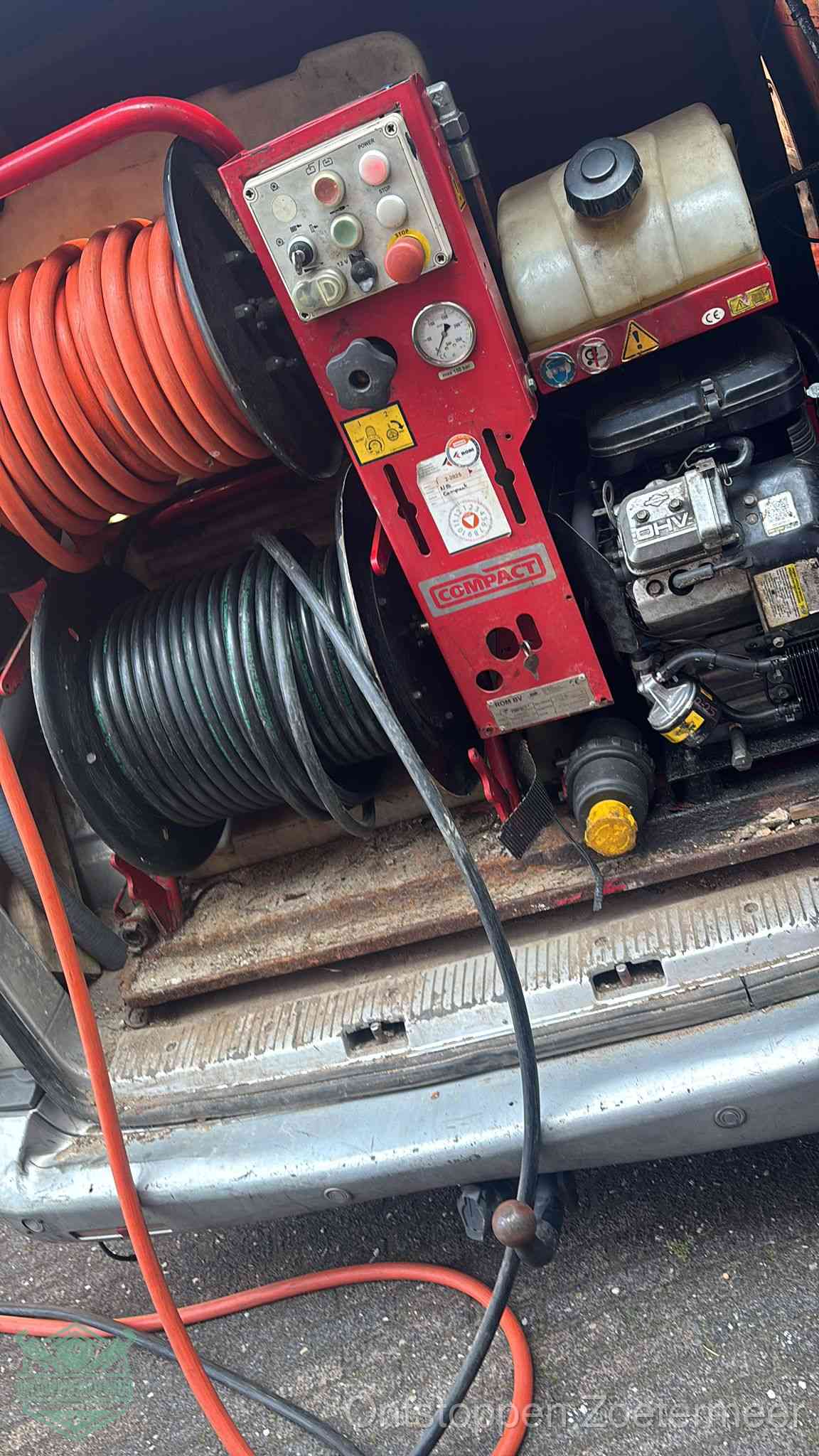 Een rood hogedruk-rioolreinigingstoestel in de laadbak van de bedrijfsbus, apparatuur voor een hardnekkige afvoerverstopping in Zoetermeer