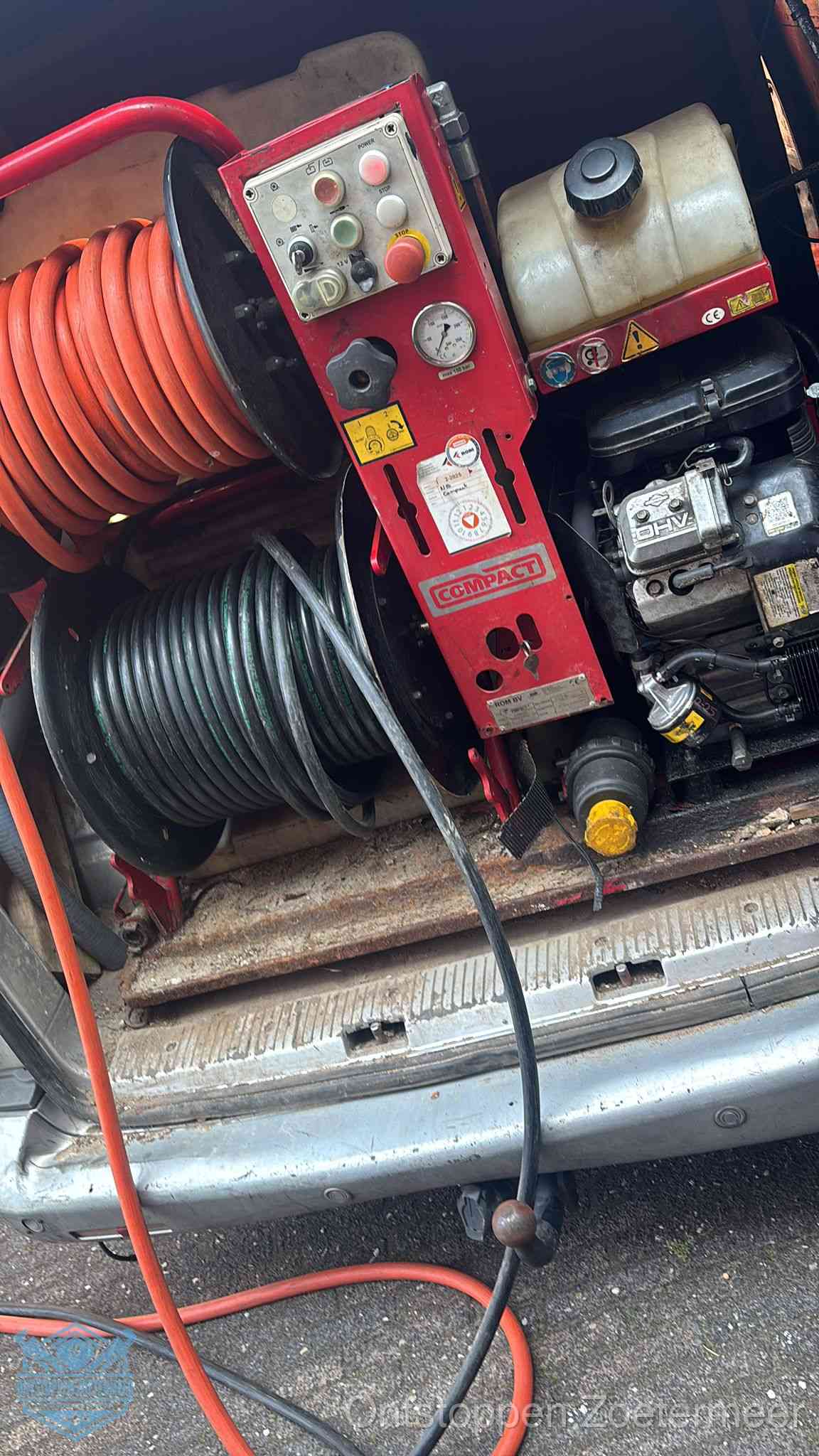 Een rood hogedruk-rioolreinigingstoestel met slangen in de laadbak van de bedrijfsbus, apparatuur voor een hardnekkige wc-verstopping in Zoetermeer