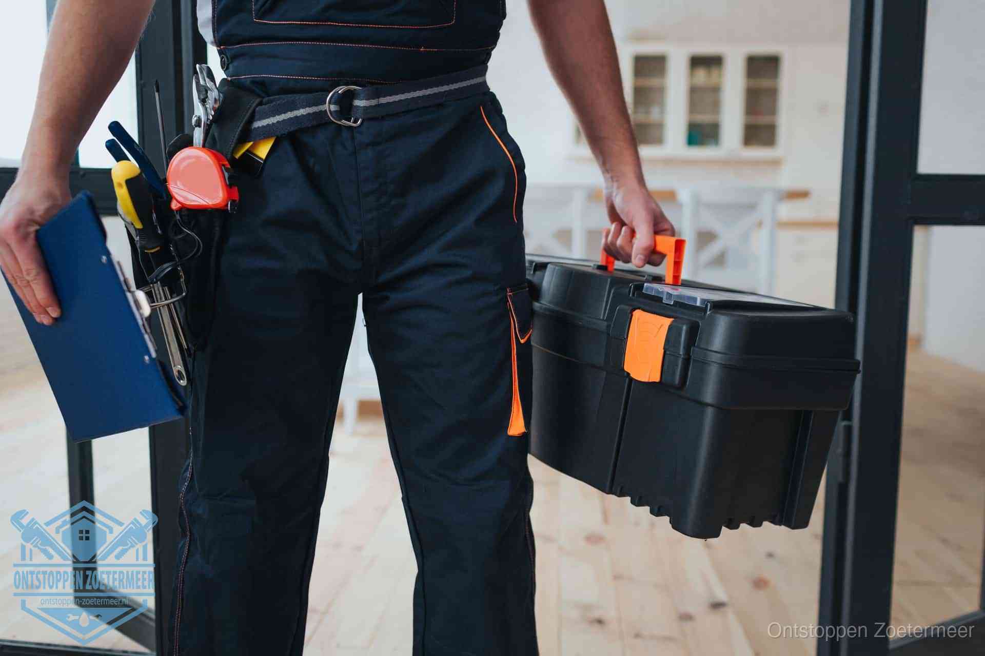 Een monteur met gereedschapsriem en klembord in een keuken, klaar om een transparante prijs voor het gootsteen ontstoppen in Zoetermeer te geven