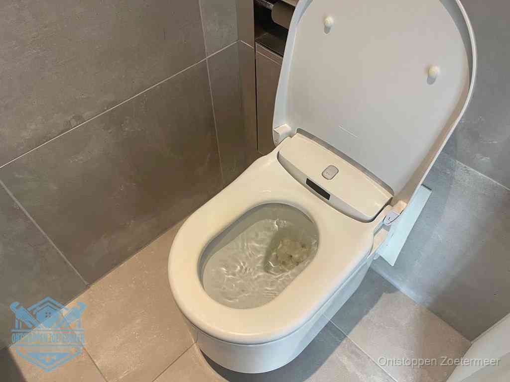 Een toiletpot vol troebel water met drijvend papier en restanten, de meest voorkomende oorzaak van een verstopte wc in Zoetermeer